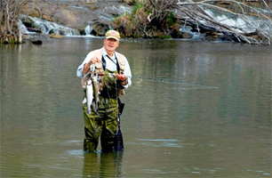 An angler holds up his stringer after adding another rainbow trout at the Blue River Public Fishing and Hunting Area. (Photo by wildlifedepartment.com)