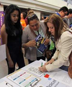 Regina Bircham (right) informs a family about education options available, including a proposed Catholic high school at the ChoiceMatters table at a recent education event. ChoiceMatters is hosting a free School Choice Expo on Jan. 28 from 6 to 8 p.m. at the Greenwood Cultural Center.